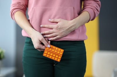 Eine Frau hält einen Blister mit Tabletten zur Behandlung einer Blasenentzündung